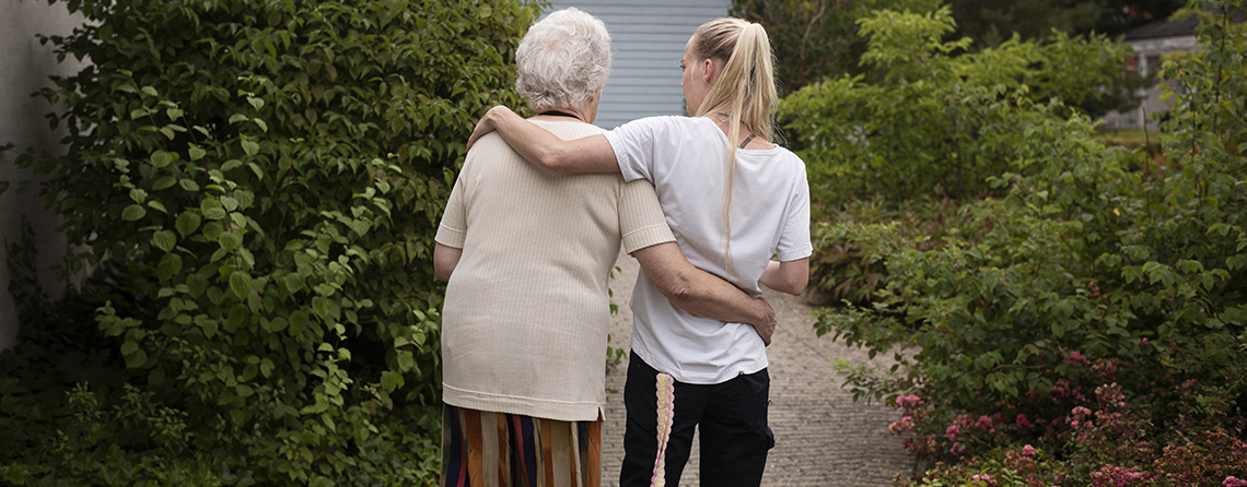 Medarbejder og ældre borger holder om hinanden. Foto: Sofia Busk.